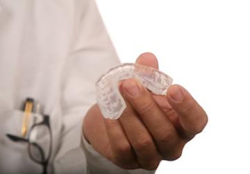 dentist holding a mouthguard for bruxism