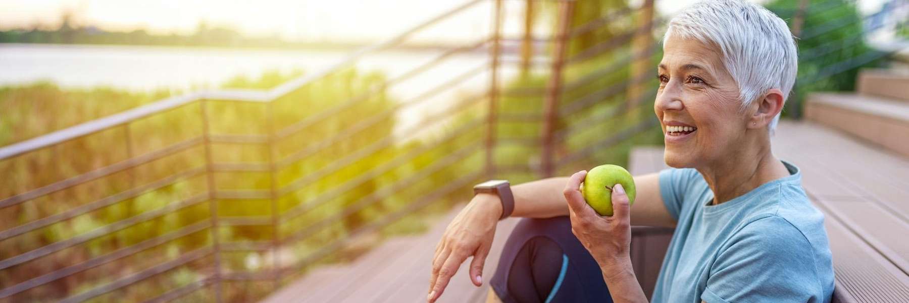 woman eating an apple sitting on the stairs outside, tuscaloosa al