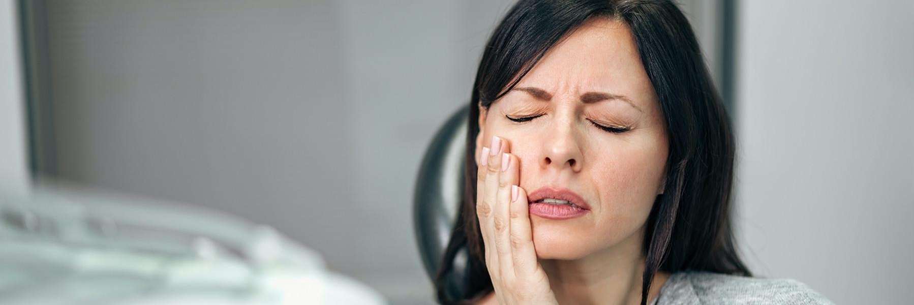 woman holding jaw from tooth pain, tuscaloosa al